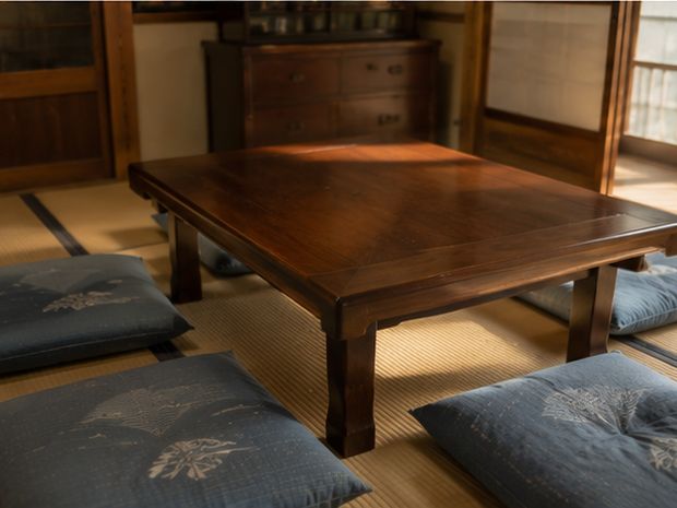 畳の部屋に置かれた木の食卓と座布団。